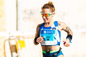 Photo of a female runner with sunglasses on running in the Zurich marathon.