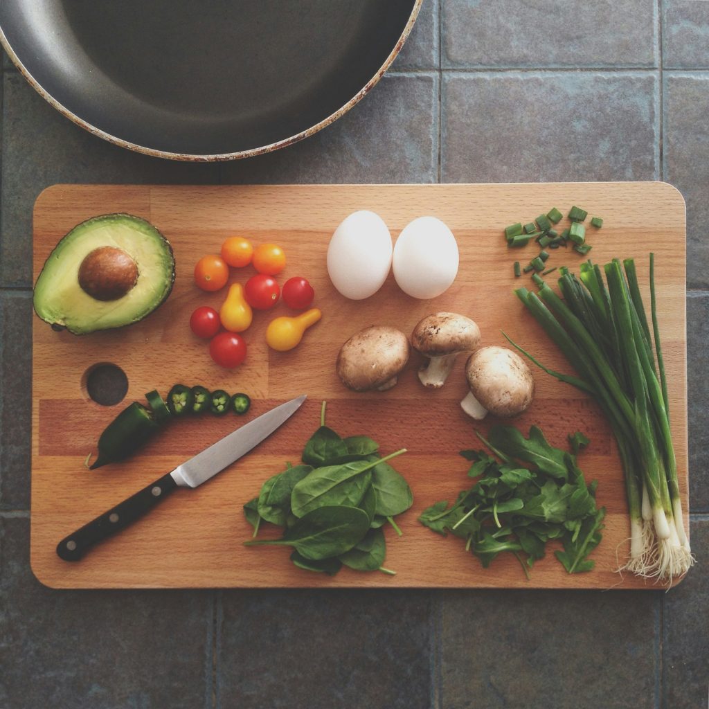 An example of fueling your morning run with a wooden chopping board laid out with eggs, avocado and greens