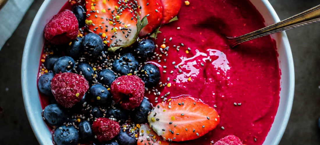 top down view of a smoothie bowl with various berries on the left