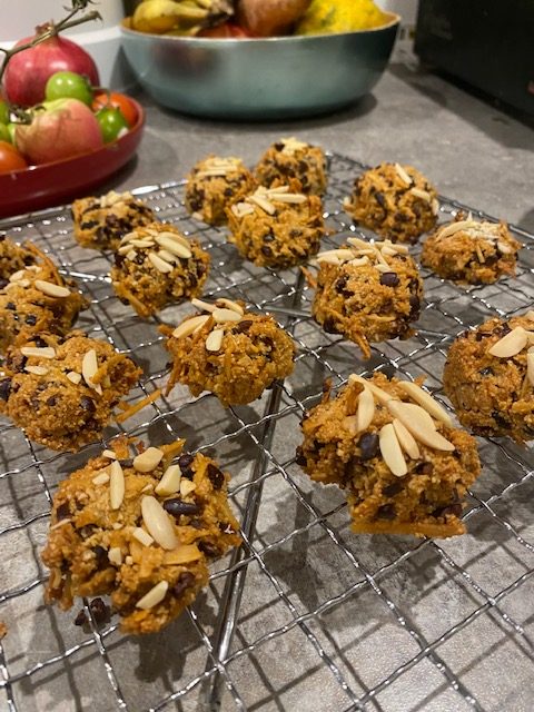 16 cookies cooling on a wire rack, topped with slivered almonds