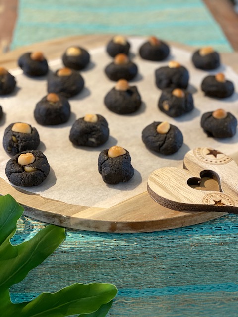 wooden plate of cookies with macadamias on top